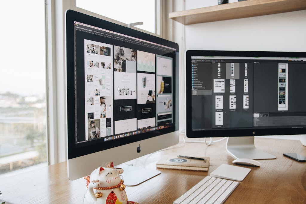 A stylish workspace featuring dual monitors and a lucky cat figurine, ideal for technology and design themes.