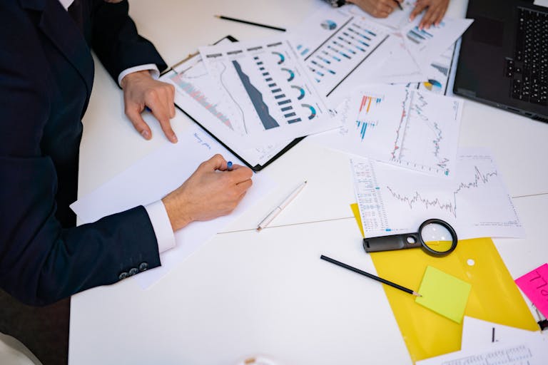 Close-up of a desk cluttered with financial charts, graphs, and reports, perfect for business and finance themes.
