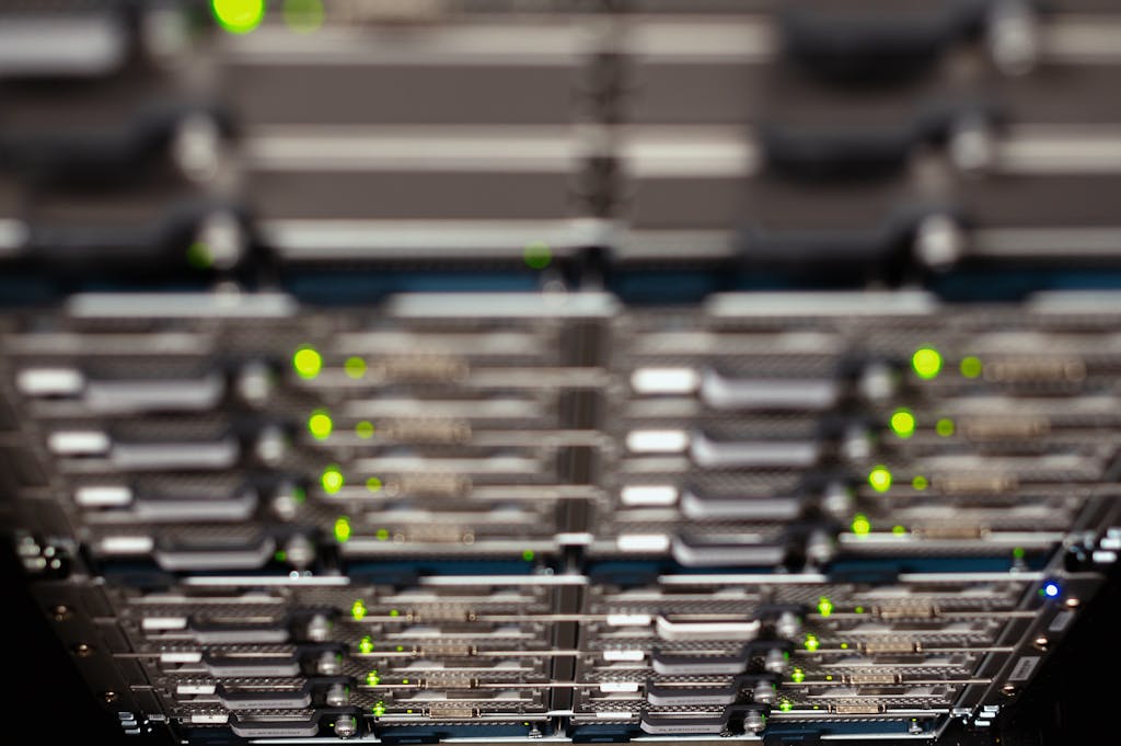 Close-up of a network server rack with blinking LEDs, showcasing Ethernet connections and patch panels.