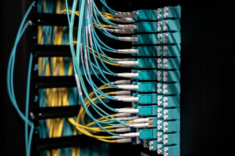 Closeup of switch in server with connectors and adapters connected to plastic device in dark room on blurred background inside