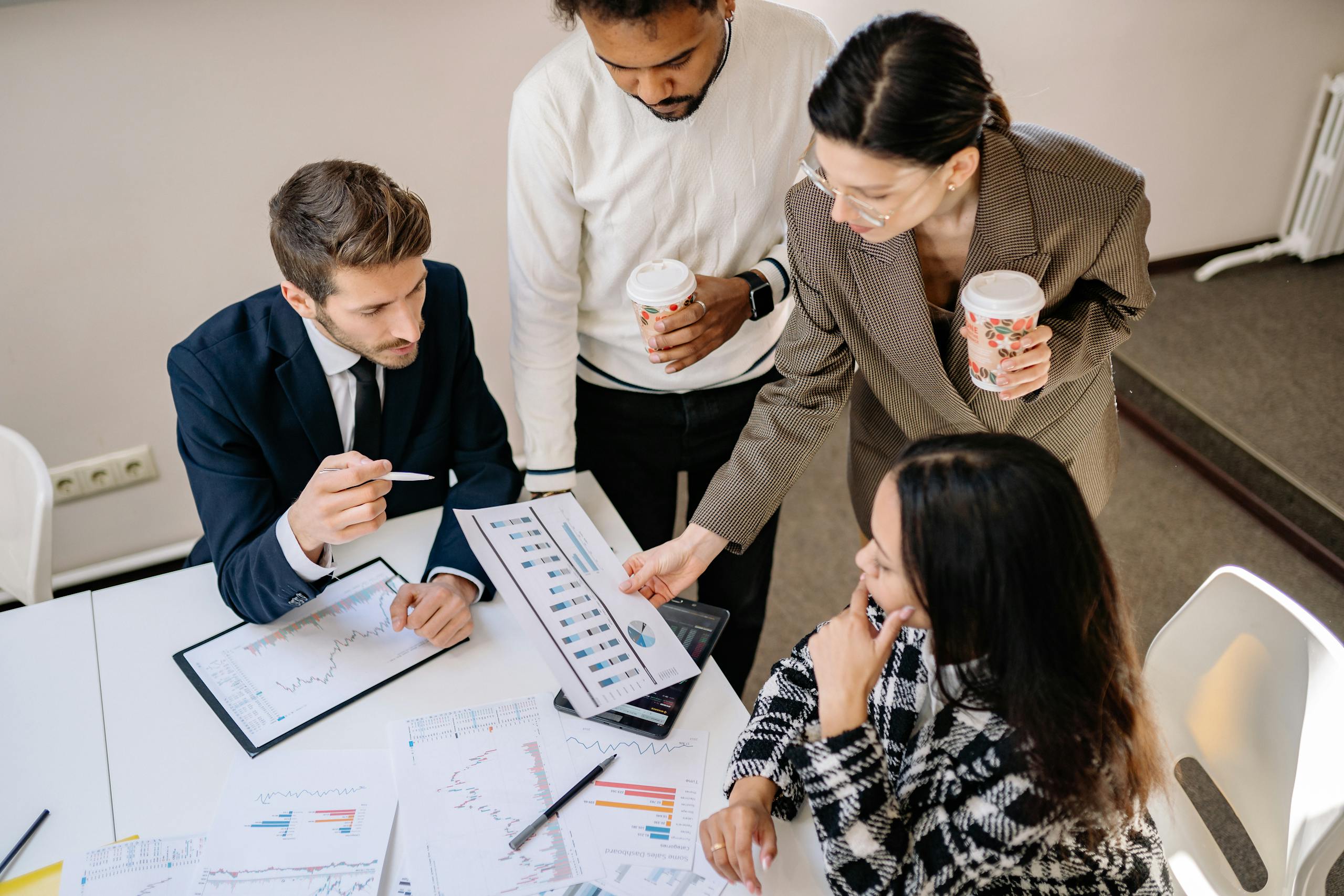 Four colleagues discuss data and strategy in an office setting.