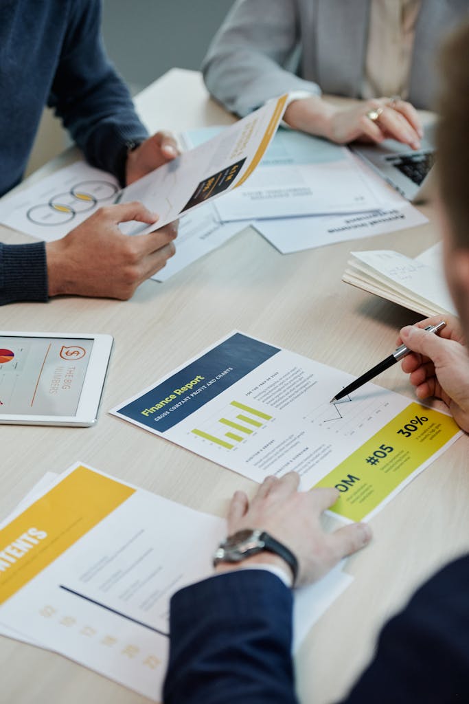 Professionals working together in an office, analyzing financial reports and documents with focus on graphs and teamwork.